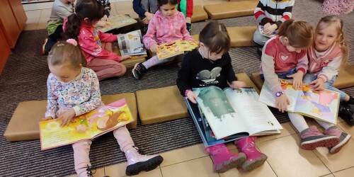 dzieci w bibliotece oglądające książki